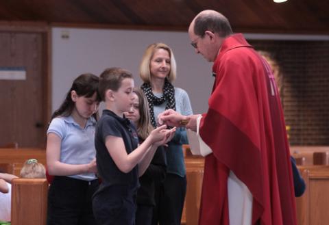 Children receive Communion from Bishop Walkowiak