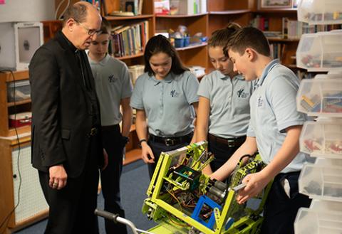 St. Mary students showing off their robotics to the Bishop