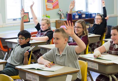 raising hands in the classroom at St. Charles 