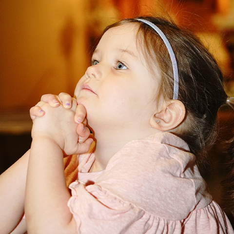 A preschooler prays.