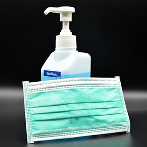 A file photo of hand sanitizer and a mask.