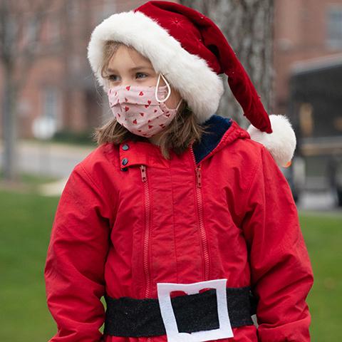 A St. Stephen student sings Christmas carols while dressed as Santa Claus.