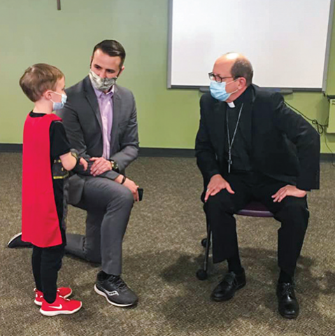 Bishop Walkowiak speaks with Saint Thomas the Apostle's assistant principal and a student.